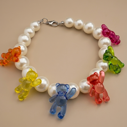 Pearl bracelet with colorful bear charms on a beige background