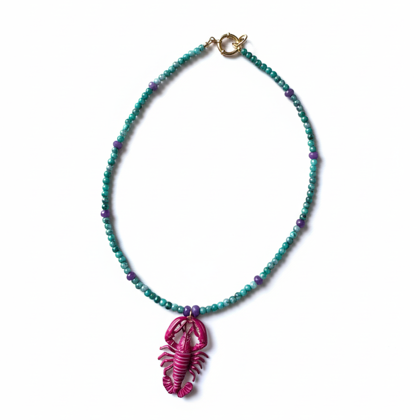 Handmade beaded necklace with green and purple beads and a pink lobster pendant_still