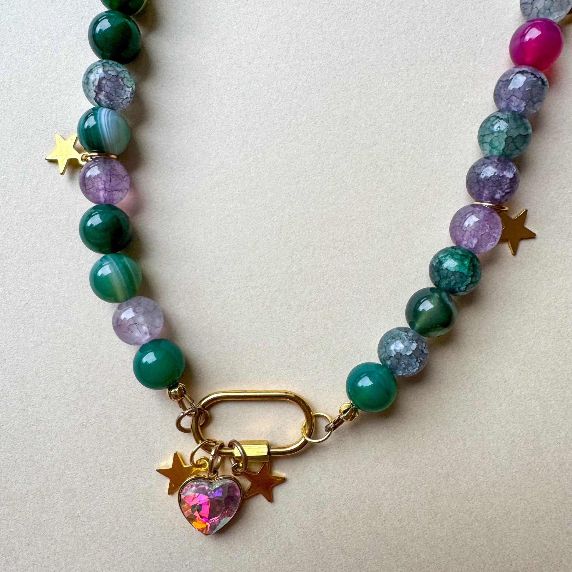 Long green beaded necklace with star accents, a silver carabiner clasp, and a small heart charm_heart charm