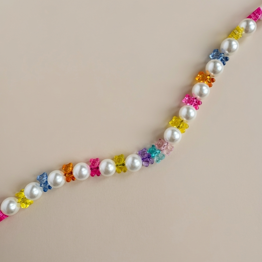 Necklace with pearls and colorful flower-shaped beads on a beige background