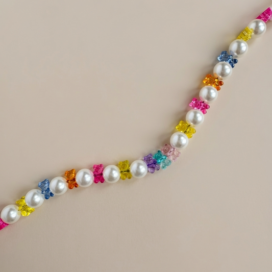 Necklace with pearls and colorful flower-shaped beads on a beige background