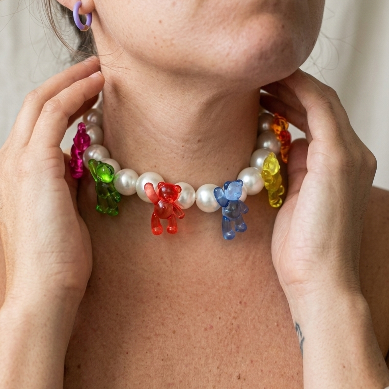 Person wearing a colorful gummy bear necklace with a pearl base.