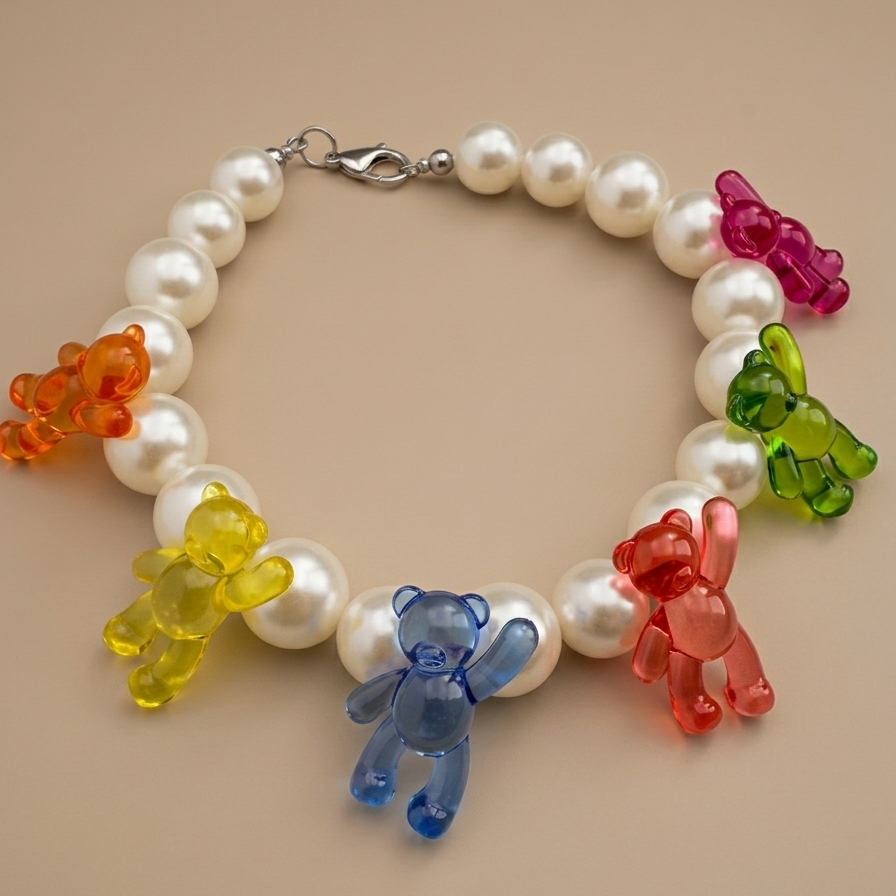 Pearl bracelet with colorful bear charms on a beige background