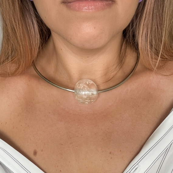 Silver stainless steel choker necklace with a large transparent bead and small gold accents_person wearing it