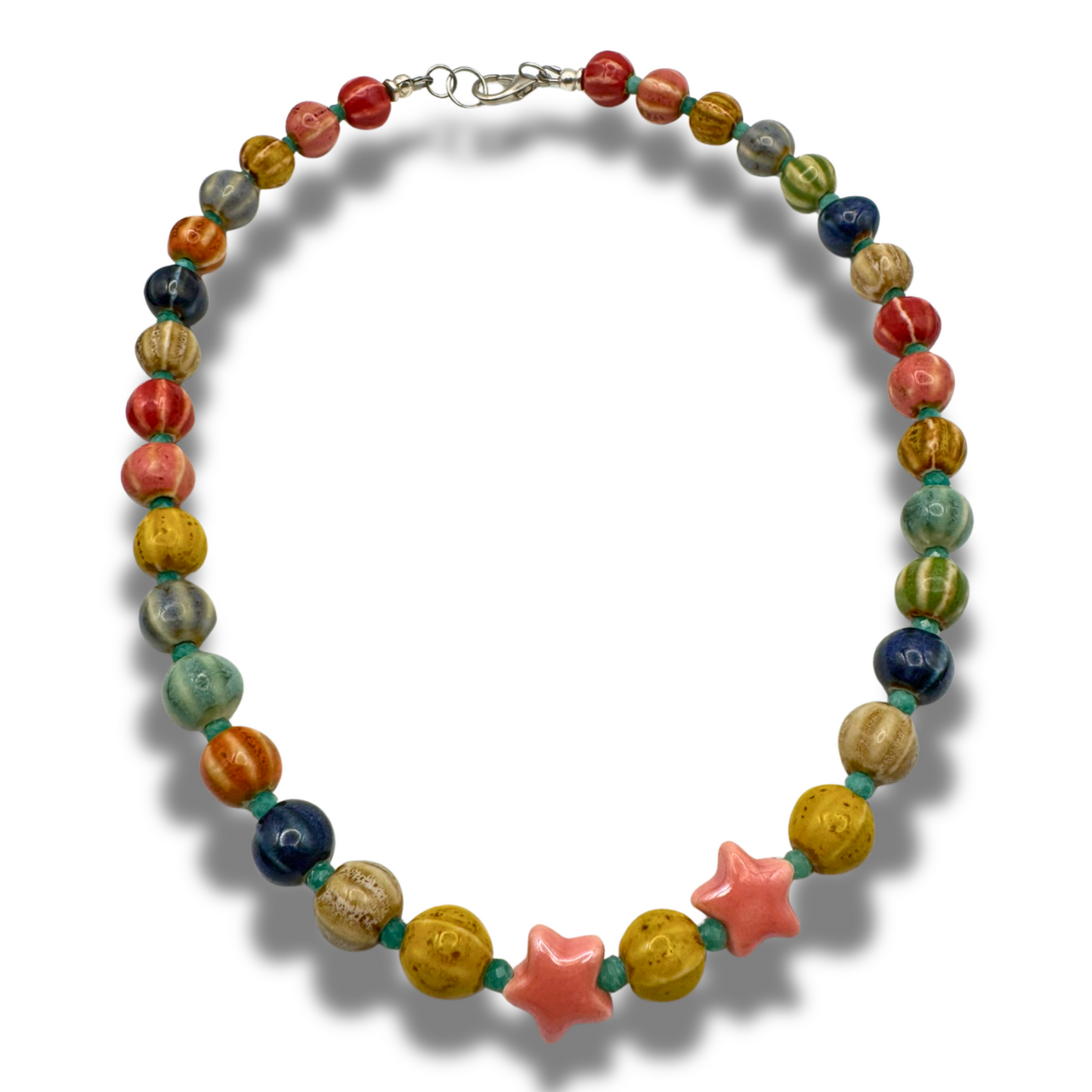 Statement necklace with colorful ceramic-glazed beads, two pink star charms, and small green spacer beads, suitable for layering or wearing alone