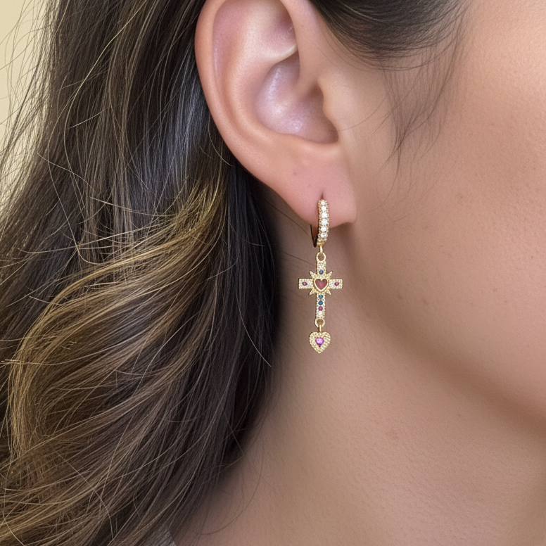 Tiny gold hoop earrings with dangling rhinestone cross charm