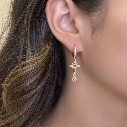 Tiny gold hoop earrings with dangling rhinestone cross charm