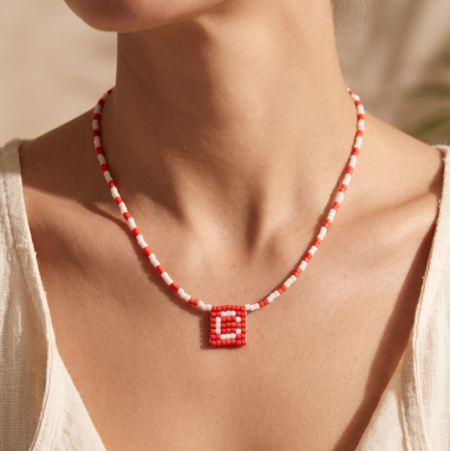Handmade Miyuki beaded necklace forming a medal-style pendant with an initial letter