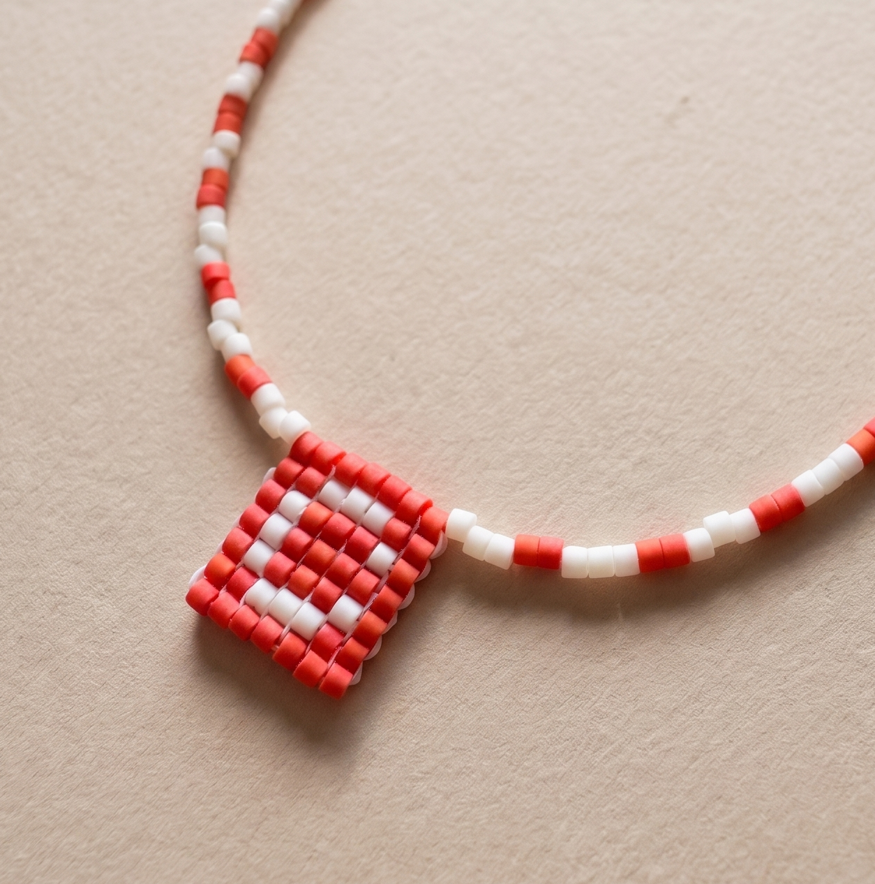 Handmade Miyuki beaded necklace forming a medal-style pendant with an initial letter