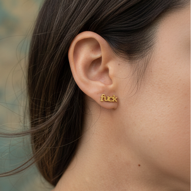Tiny gold stud earrings with the word fuck in a bold design