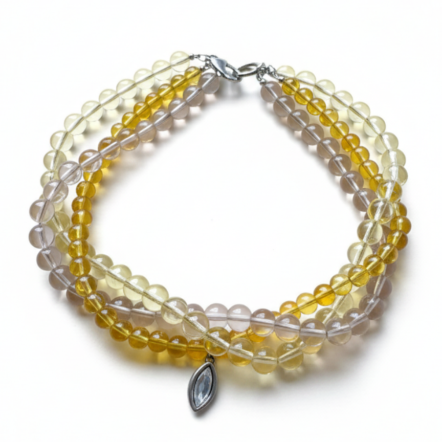 Three-strand beaded necklace in yellow and earthy tones featuring a Swarovski crystal pendant_still